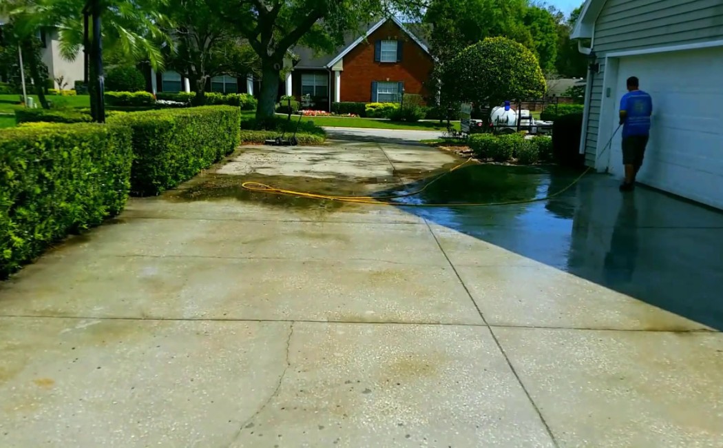 A Residential Washing Company cleaning a residential driveway and garage area, restoring concrete surfaces to a clean finish.